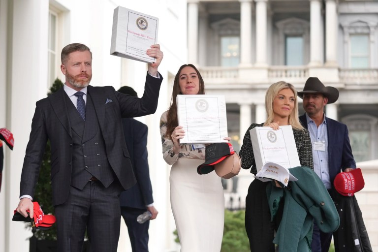 Conservative political commentator Rogan O'Handley, also known as DC Draino, from left, social media content creator Chaya Raichik and conservative political commentator Liz Wheeler hold up binders with a cover titled 