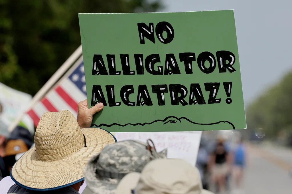 Environmental advocates and protesters at the Dade-Collier Training and Transition Airport on Tamiami Trail E, Ochopee, Fla., on Saturday, June 28, 2025, object to the "Alligator Alcatraz" being built at the facility. (Mike Stocker /South Florida Sun-Sentinel via AP)