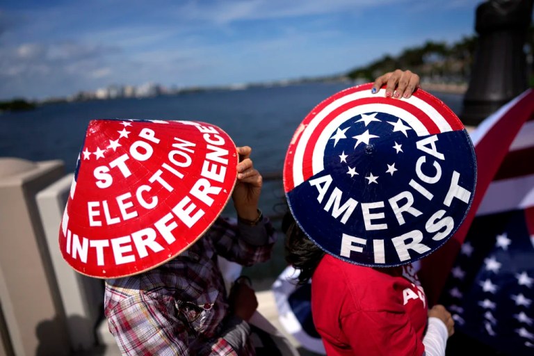 Members of a group from Southern California called Patriots for Freedom, who were in town to attend a fundraiser for Republican presidential candidate former President Donald Trump, wear decorated hats as they show their support for Trump on the bridge outside his Mar-a-Lago estate, Friday, Feb. 16, 2024, in Palm Beach, Fla. (AP Photo/Rebecca Blackwell)