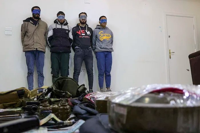 In this photo released by Syrian State TV, four suspects arrested in connection with an alleged plot by ISIS are shown standing against a wall in Damascus, Syria, Saturday, Jan. 11, 2025. Syrian intelligence officials, operating under the country's new de facto government, thwarted an attempt by ISIS to detonate a bomb at the Shiite shrine of Sayyida Zaynab in the Damascus suburb, according to state media reports on Saturday.