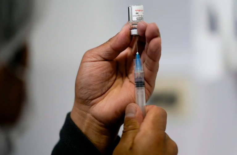 A healthcare worker prepares a shot.