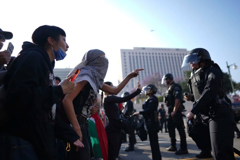 Protesters confront Los Angeles police department personnel in riot gear in downtown Los Angeles on Monday, June 9, 2025.