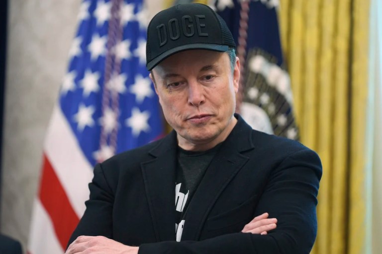 Elon Musk attends a news conference in the Oval Office.