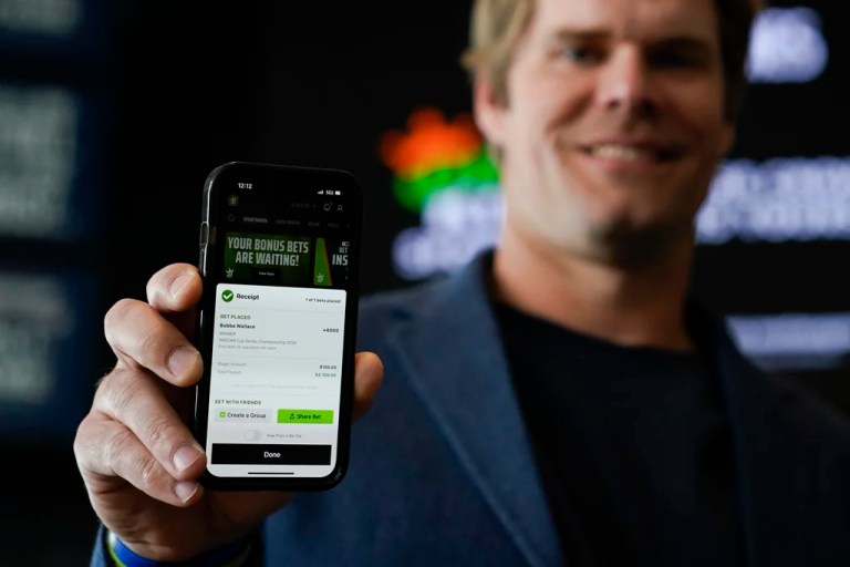 FILE - Fox Sports broadcaster Greg Olsen, who placed the first ceremonial bet in North Carolina, shows his receipt during a DraftKings event celebrating the launch of mobile and online sports wagering across the state at the NASCAR Hall of Fame, Monday, March 11, 2024, in Charlotte, N.C. (AP Photo/Erik Verduzco, File)