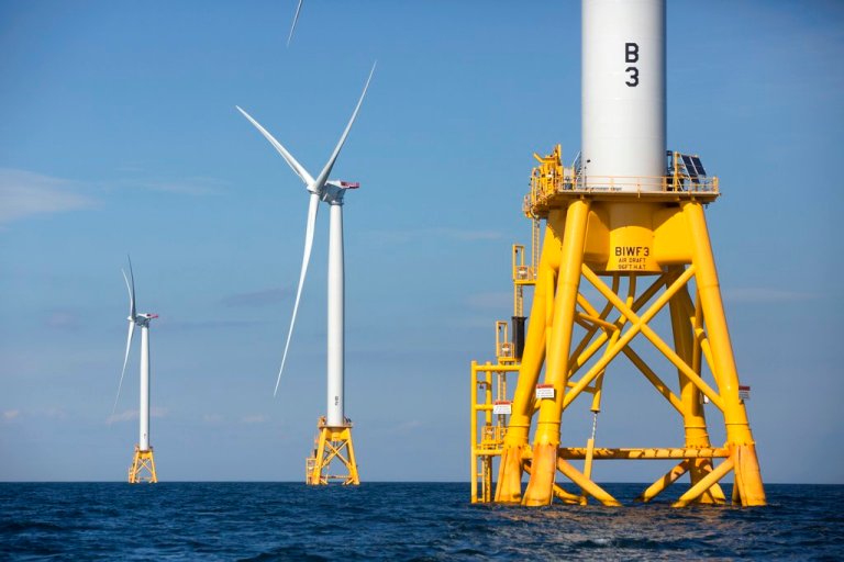 Three wind turbines stand in the water.