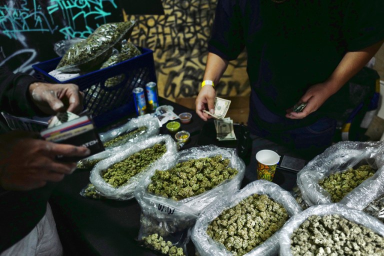 A vendor makes change for a marijuana customer at a cannabis marketplace in Los Angeles.