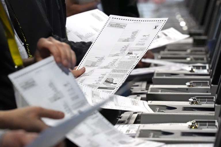 Election workers recount ballots.
