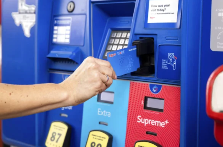 A person inserts their credit card at a gas pump.