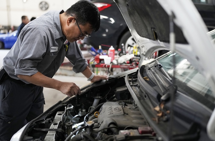 Auto mechanic Willie Chung works on a vehicle.
