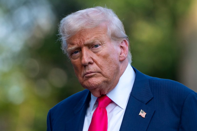 President Donald Trump stands outside.