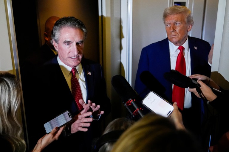 President Donald Trump watches as Interior Secretary Doug Burgum speaks to reporters.