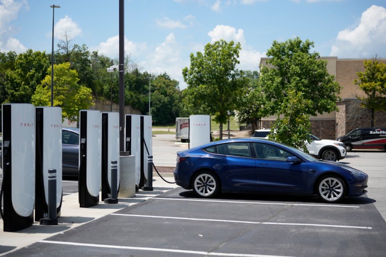A Tesla electronic vehicle is parked at a charging station.