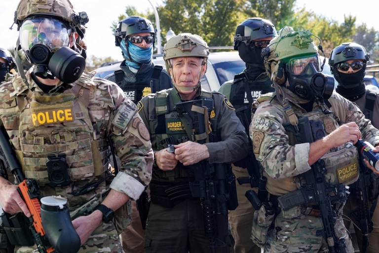 U.S. Customs and Border Protection Commander Gregory Bovino stands with federal immigration enforcement agents.