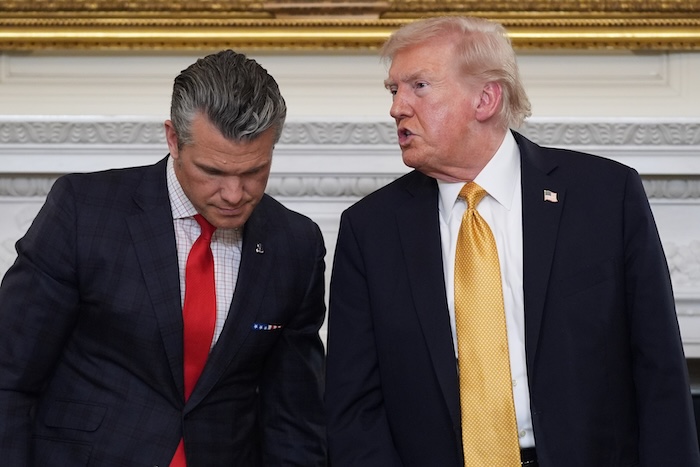 President Donald Trump talks with Defense Secretary Pete Hegseth after a roundtable on criminal cartels in the State Dining Room of the White House, Thursday, Oct. 23, 2025, in Washington.
