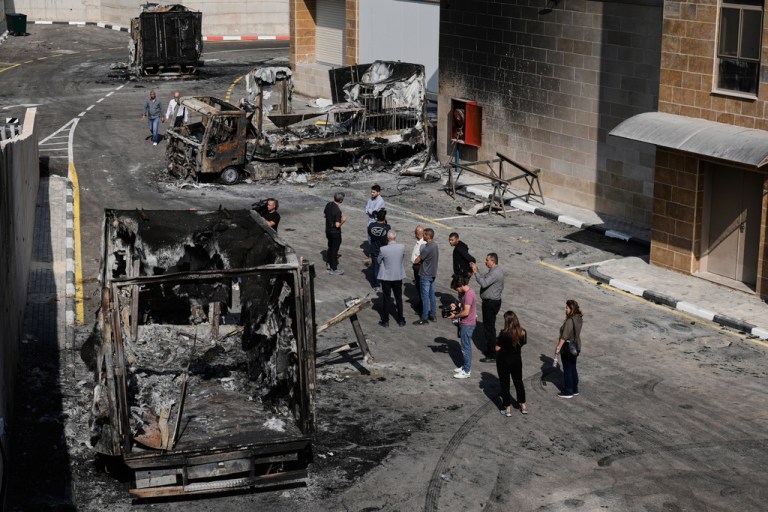 Palestinians and journalists survey damage in an industrial zone following an attack by Israeli settlers the day before in the West Bank village of Beit Lid.