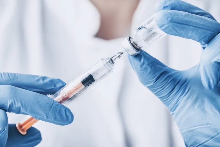 A doctor holds needle to inject a vaccine fighting disease and sickness for a patient. (Stock image)