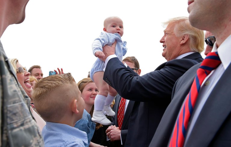 President Donald Trump hoisting up a baby.