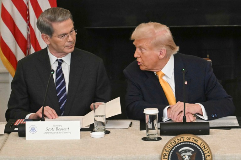President Donald Trump speaks as Treasury Secretary Scott Bessent listens.