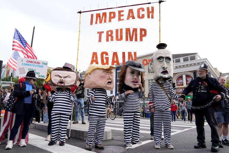 Demonstrators wear costumes and carry signs as they rally at the 14th and U street corridor before marching to the national Mall during a No Kings protest in Washington.