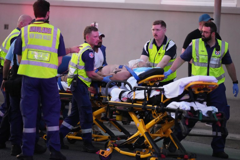 Emergency workers transport a person on a stretcher
