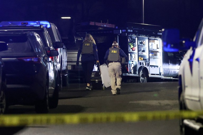 Law enforcement officers are seen outside a storage facility where a suspect in the shooting at Brown University was found dead