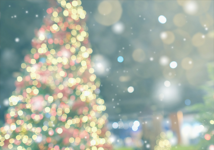 A blurred Christmas tree with lights outside.