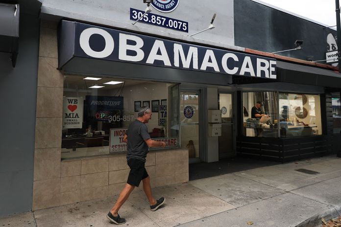 An Obamacare sign is displayed outside an insurance agency.