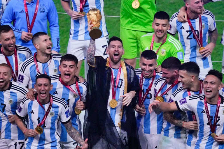 Argentina's Lionel Messi holds the trophy aloft as he celebrates with his team at the end of the World Cup final soccer match between Argentina and France at the Lusail Stadium in Lusail, Qatar, Sunday, Dec. 18, 2022.