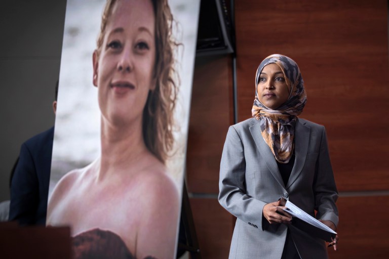 Rep. Ilhan Omar (D-MN) walks beside a photograph of Renee Good, the woman shot and killed in her car by a federal immigration officer in Minneapolis, during a news conference with the Congressional Progressive Caucus as they announce an effort to limit funding for the Department of Homeland Security at the Capitol.