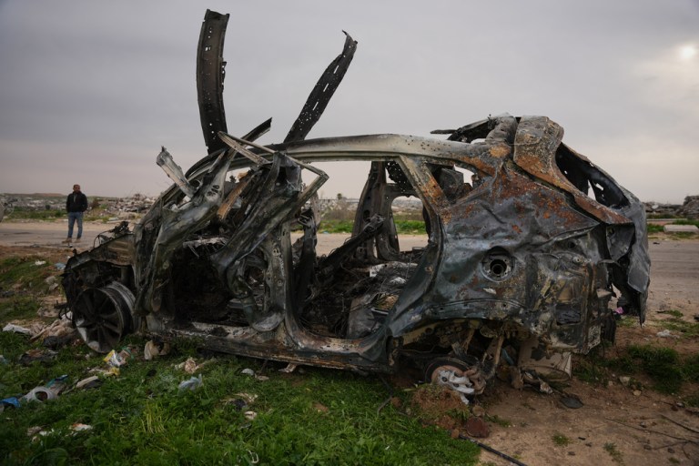 A man stands next to an Egyptian committee's vehicle that was hit by an Israeli strike, killing three Palestinian journalists, in Zahraa, central Gaza Strip, Wednesday, Jan. 21, 2026.