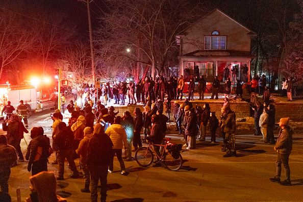 Residents confront federal officers following a shooting.