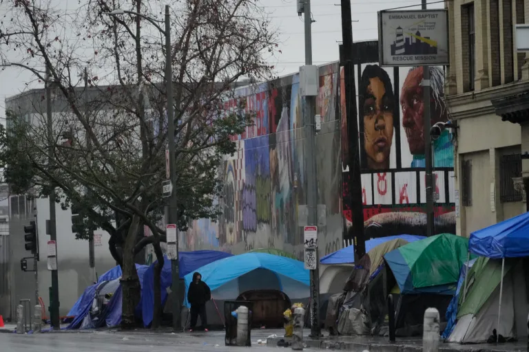 People suffering from homelessness set large tents next to the Emmanuel Baptist Rescue Mission.