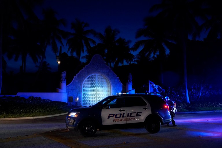 Police stand outside an entrance to former President Donald Trump's Mar-a-Lago estate