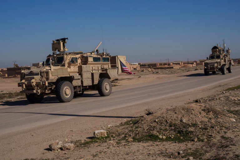 A U.S. military convoy drives along a road in northeastern Syria.