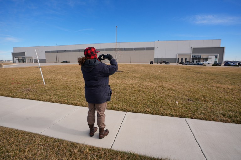 A man takes photos of a warehouse.
