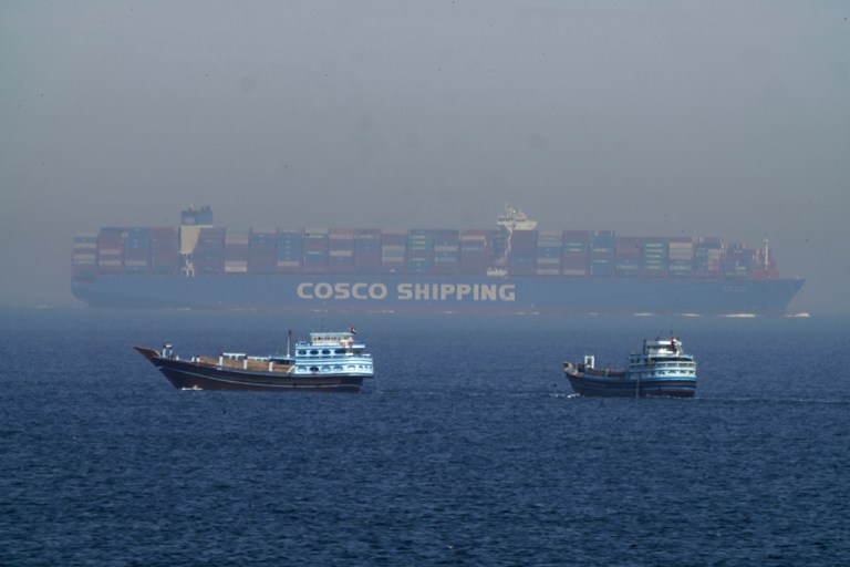 Two traditional dhows sail by a large container ship in the Strait of Hormuz, May 19, 2023. (AP Photo/Jon Gambrell, File)