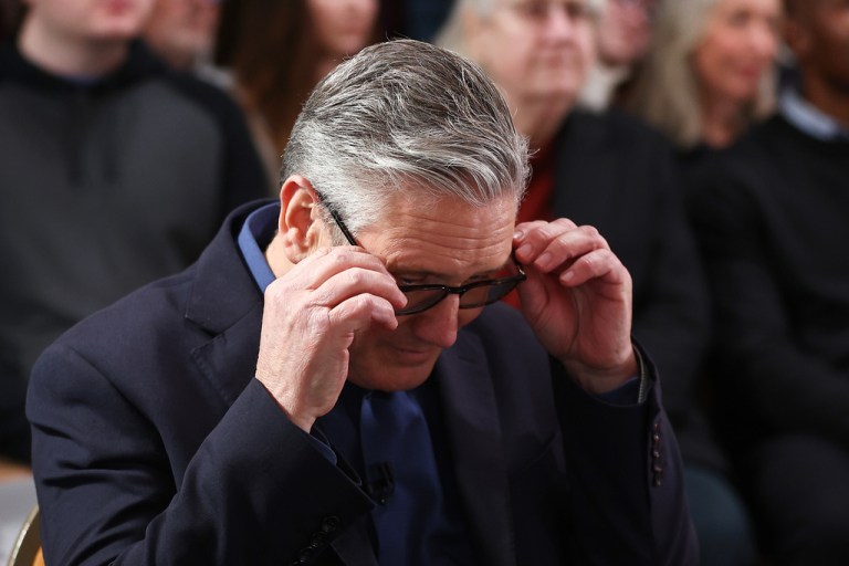 U.K. Prime Minister Keir Starmer adjusts his glasses as he waits to deliver a speech.