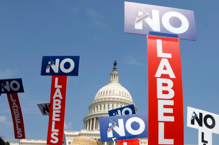 People with the group No Labels hold signs during a rally on Capitol Hill in Washington, July 18, 2011. The Arizona Democratic Party is looking to force No Labels to disclose its donors or lose its status as a political party, an escalation of Democrats' efforts to block a group they worry will boost former President Donald Trump's chances of returning to the White House.