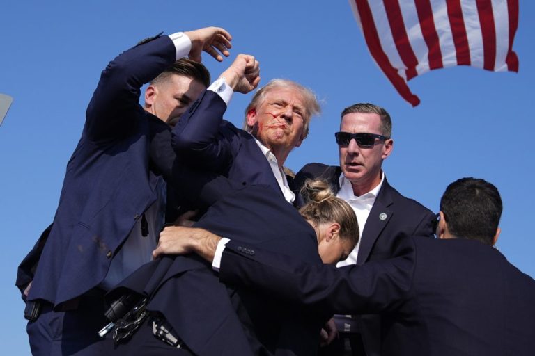 Republican presidential candidate former President Donald Trump surrounded by U.S. Secret Service agents following an assassination attempt.
