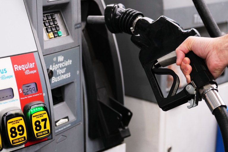 A hand holding a gasoline pump