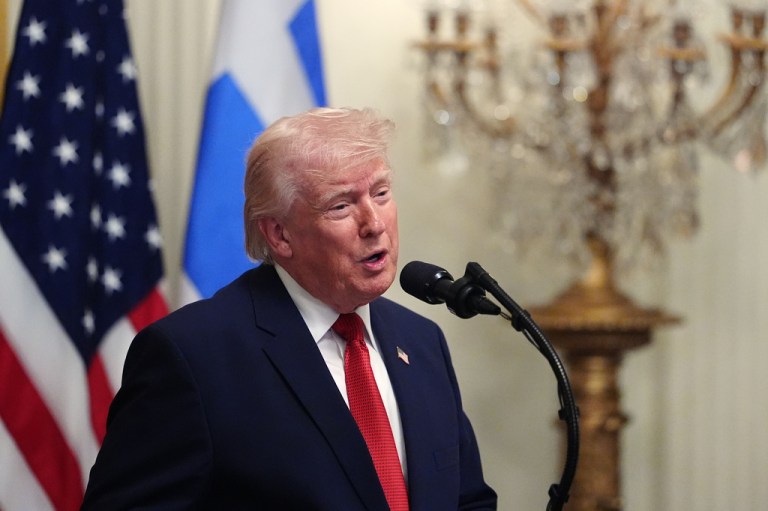Trump speaking into a mic.