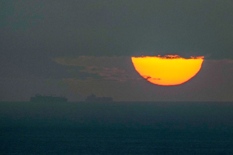 Ships sail through the Arabian Gulf toward the Strait of Hormuz as the sun sets in the United Arab Emirates Monday, March 23, 2026.