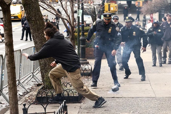 A left-wing activist flees after throwing a homemade explosive device towards police during a protest.