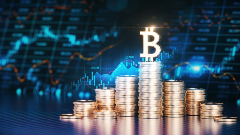The Bitcoin Symbol on Top of Stacks of Coins in Front Of a Financial Chart in the Background. Business and Finance concept.