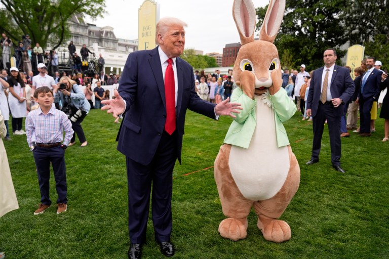 President Donald Trump, accompanied by an Easter Bunny, takes part in the White House Easter Egg Roll.