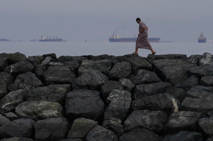 A man walks on the bank of the Strait of Hormuz