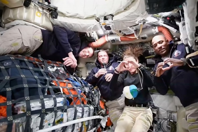This image from video provided by NASA shows the Artemis II crew Commander Reid Wiseman, second from left, thanking the families of the crew while speaking with NASA Mission Control in a video conference while en route to the moon, Thursday, April 2, 2026, as Canadian astronaut and mission specialist Jeremy Hansen, far left, looks on and mission specialist Christina Koch and pilot Victor Glover, far right, make hearts with their hands.