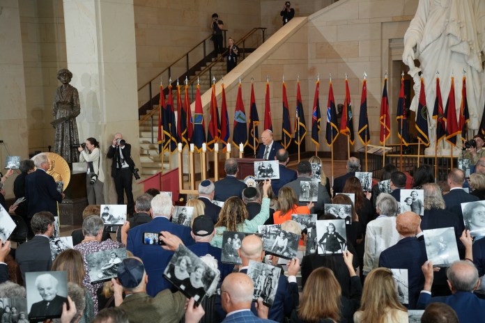 Attendees at the Holocaust Memorial Museum’s National Commemoration of the Days of Remembrance at Capitol Hill hold photos of Holocaust victims on April 14, 2026 (Washington Examiner/Sydney Topf).