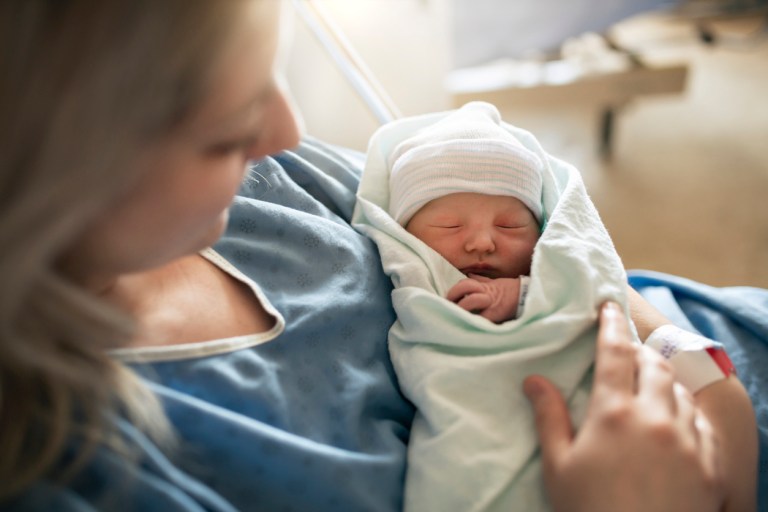 A Mother with her newborn baby at the hospital a day after a natural birth labor birth rate children babies pregnancy