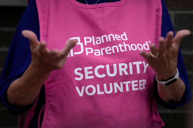 A Planned Parenthood clinic patient escort stands outside the building Thursday, July 18, 2024, in Ames, Iowa. (AP Photo/Charlie Neibergall)